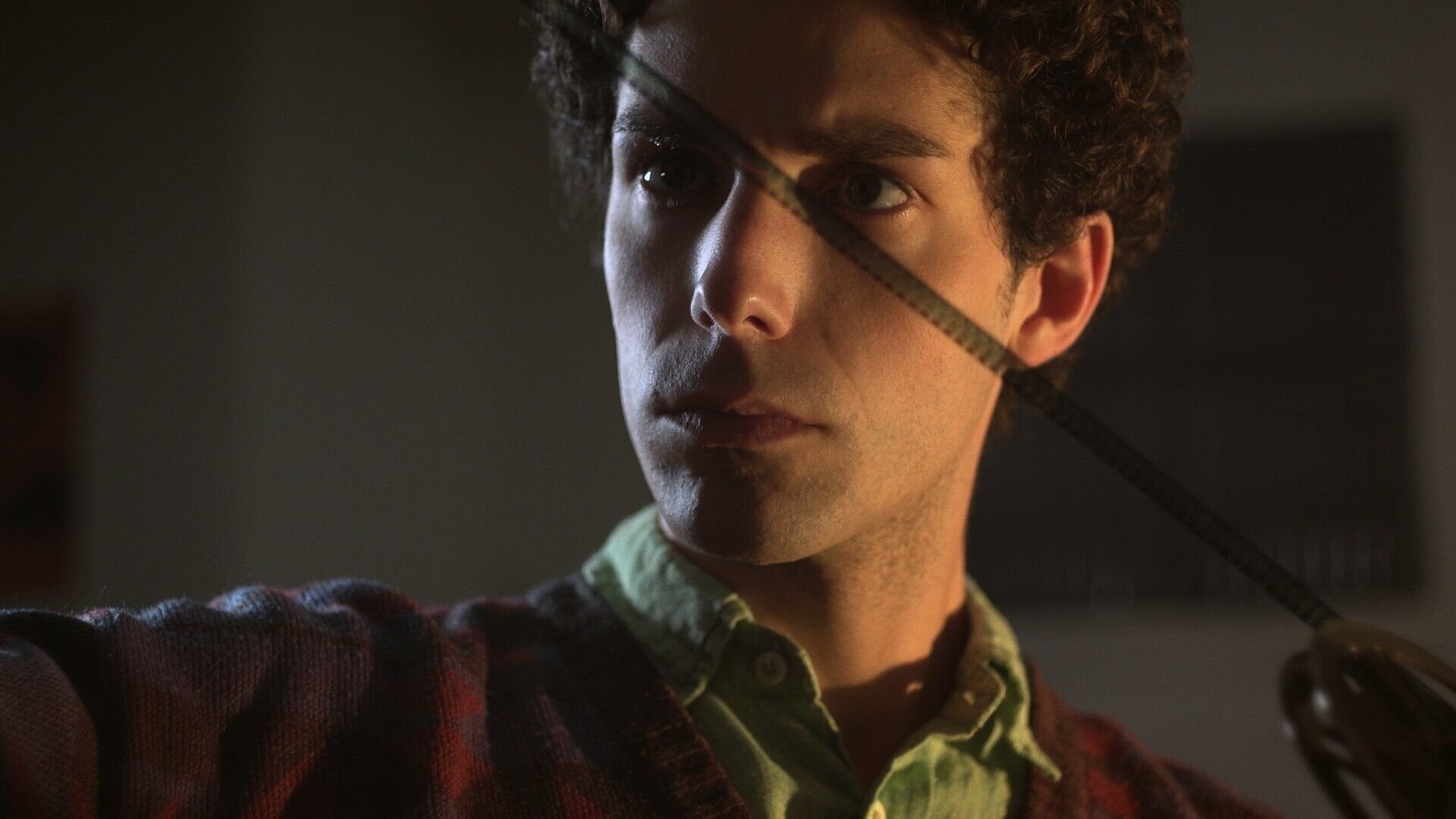 Portrait framed by a strip of film in warm light.